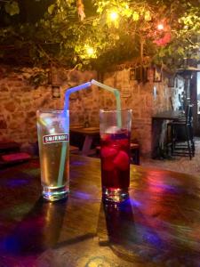 two drinks are sitting on a wooden table at Kuyu Beergarden Hostel in Antalya