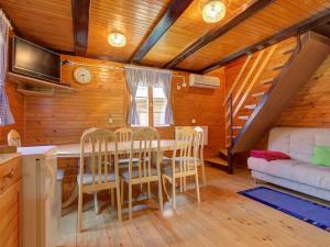 a dining room with a table and chairs and a couch at Chalet 68 Terme Čatež with Swimming tickets in Brežice
