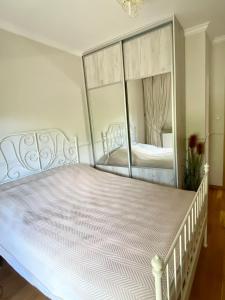 a bedroom with a white bed with a large mirror at Apartament Nadmorski Dwór- Gdańsk in Gdańsk