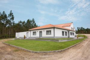 Ein weißes Haus auf einer unbefestigten Straße in der Unterkunft Quinta do Vale Vendeiro in Figueira da Foz