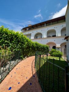 a fence in front of a building with a walkway at Antica Residenza la Vela in Meta