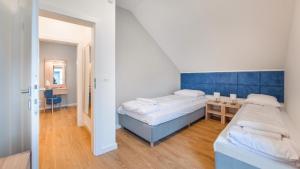 a bedroom with two beds and a small table at Apartamenty Sun & Snow Horizon Park in Dziwnówek