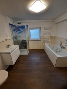 ein Badezimmer mit einer Badewanne, einem Waschbecken und einem WC in der Unterkunft Ferien im Fischerhaus in Wismar