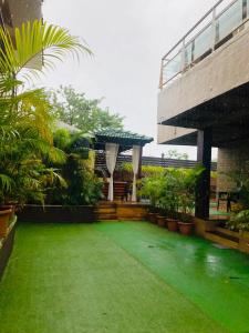 um jardim com relva verde e um edifício em Slice Of Heaven.3-Bedroom Villa with Pool & Gazebo em Lonavala
