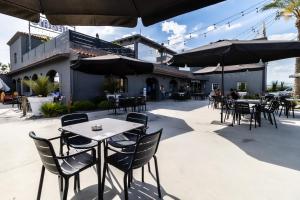 un patio al aire libre con mesas, sillas y sombrillas en Hotelet elRetiro, en Cambrils