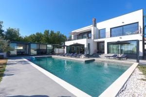 a house with a swimming pool in front of a house at Villa Valdo by Istra Vacation in Marčana