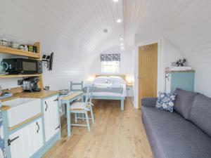 uma cozinha e sala de estar com um sofá e uma mesa em Laird Lodge 2 em Lockerbie
