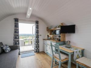 een keuken en een woonkamer met een tafel en een bank bij Laird Lodge 2 in Lockerbie