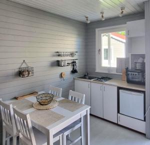 a kitchen with a table and a table and chairs at Domki z jacuzzi nad zatoką in Puck
