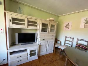 una sala de estar con TV en un armario blanco en Casa SIDRO, en Novales
