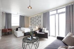 a living room with a bed and a table at The Hyde All Suite Hotel in Cape Town +80 photos