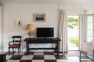 a living room with a desk with a television on it at Chalet en El Sardinero a 5 minutos de la playa. in Santander