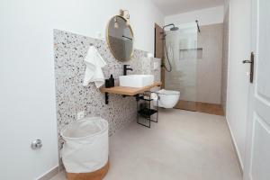 a bathroom with a sink and a toilet and a mirror at Apartmani Barbaroša in Sveti Filip i Jakov