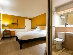 een slaapkamer met een bed, een toilet en een wastafel bij Greet Hôtel Villeneuve la Garenne - rénové in Villeneuve-la-Garenne