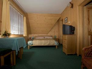 a bedroom with a bed and a flat screen tv at Willa u Krzeptowskich in Kościelisko