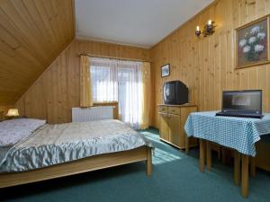 a bedroom with a bed and a tv and a table at Willa u Krzeptowskich in Kościelisko