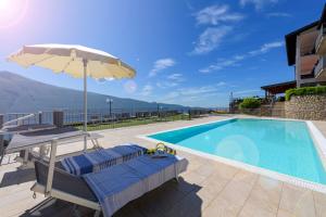 uma piscina com guarda-sol e cadeiras e uma piscina em Residence Ruculì - Ruculì Hospitality em Tignale