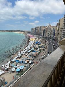 Blick auf einen Strand mit Sonnenschirmen und Menschen in der Unterkunft شقق بانوراما شاطئ الأسكندرية كود 5 in Alexandria