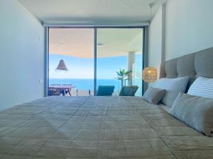 sypialnia z dużym łóżkiem i widokiem na ocean w obiekcie Stupa Hills IV F33G - Superb Sea View Apartment w mieście Benalmádena