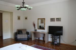a living room with a television and a table with a chair at Apartment Centrum in Novi Sad