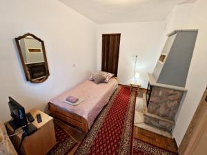 a small bedroom with a bed and a mirror at Dalia in Iwonicz-Zdrój