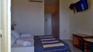 スカラ・ケファロニアにあるPorto Skala Hotel Villageのベッドとテーブルが備わるホテルルームです。