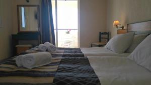 a hotel room with a bed with towels on it at Porto Skala Hotel Village in Skala
