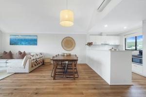 a kitchen and living room with a table and a couch at A Stones Throw Gnarabup in Gnarabup