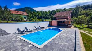 a villa with a swimming pool and a house at Holiday Home Emir in Račić