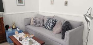 ein Sofa mit Kissen darauf im Wohnzimmer in der Unterkunft Le Gîte du Lapin Bleu in Baigneux-les-Juifs