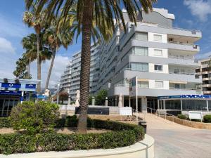 a tall white building with palm trees in front of it at SERVICE APART LAZARO - Apartamentos Aguamarina 43-C in Calpe