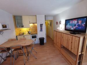 una cocina con mesa y TV en un soporte en La Foux d'Allos - Studio 4 couchages, très proche centre station, en La Foux