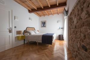 a bedroom with a bed and a stone wall at Lugar das Marías in Jove