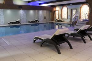 a large swimming pool with chairs in front of it at Ardencote in Henley in Arden
