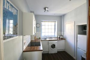 uma cozinha com um lavatório e uma máquina de lavar roupa em Mid-mile em Edimburgo