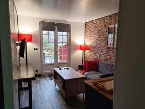 a living room with a couch and a table at Auberge De La Durdent in Héricourt-en-Caux