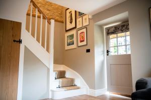 um corredor com escadas que levam a uma casa com uma porta em The Cotley Inn em Wambrook