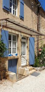 un edificio con persianas azules y una puerta en Le Gîte du Lapin Bleu, en Baigneux-les-Juifs