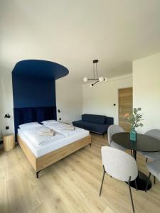 1 dormitorio con 1 cama, mesa y sillas en Dubois Apartments Kołobrzeg en Kołobrzeg