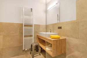 a bathroom with a sink and a mirror at Living Lerchna - Apartment Abendrot in Maranza +22 photos