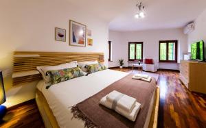Schlafzimmer mit einem großen Bett mit einem Kopfteil aus Holz in der Unterkunft Maregnago Relais in Marano di Valpolicella