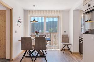 cocina y comedor con mesa y sillas en Apartment Abendrot, en Maranza