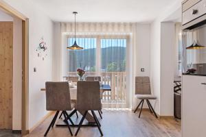 a kitchen and dining room with a table and chairs at Living Lerchna - Apartment Abendrot in Maranza