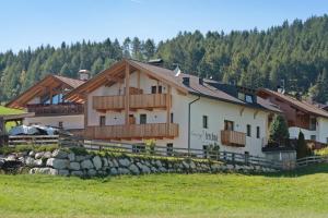 a large white house with a fence in a field at Living Lerchna - Apartment Abendrot in Maranza