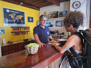 un hombre parado en un mostrador en una barbería con una mujer en HI Hostel Chapada, en Lençóis