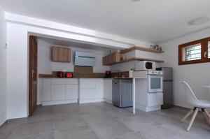 a kitchen with white appliances and a table and chairs at Chalet Les Cols - Chambres avec terrasse & jardin - proche de la nouvelle gare in Saint-Jean-de-Maurienne