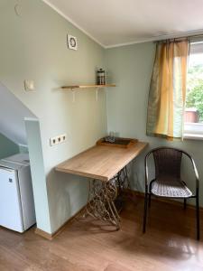 una mesa y una silla en una habitación con ventana en Jasmīni, en Ventspils