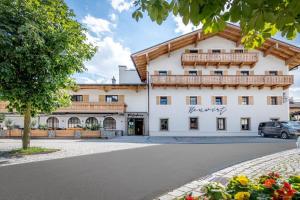 duży biały budynek z balkonem w obiekcie NEUWIRT - Boutiquehotel & Wirtshaus w mieście Bad Vigaun