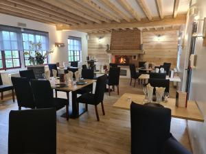 a dining room with tables and chairs and a fireplace at Auberge De La Durdent in Héricourt-en-Caux