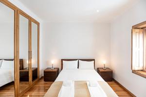 a bedroom with a bed and two mirrors at Mindelo Villa Beach by LovelyStay in Mindelo